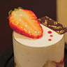 イチゴのパフェ／たっぷりと注がれた生クリームに苺のアクセント。気軽に食べられる、イチゴのパフェ。[ラズベリーとオレンジのソースに爽やかなクリームのイチゴのパフェ。入れ物の中に凝縮されたイチゴの美味しさを最後まで楽しめる小さな「パーフェクト」スイーツです。]